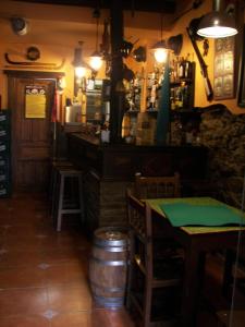 a restaurant with a table and a bar and a barrel at Hotel Doña Gaudiosa in Pola de Lena