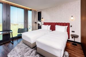 Una cama o camas en una habitación de Radisson Blu Hotel at Porsche Design Tower Stuttgart