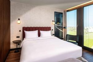 Un pat sau paturi într-o cameră la Radisson Blu Hotel at Porsche Design Tower Stuttgart