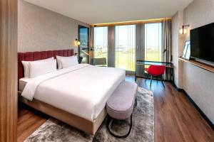 Un pat sau paturi într-o cameră la Radisson Blu Hotel at Porsche Design Tower Stuttgart