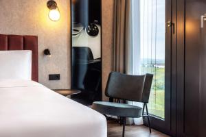Un pat sau paturi într-o cameră la Radisson Blu Hotel at Porsche Design Tower Stuttgart