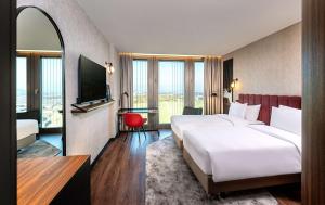 Un pat sau paturi într-o cameră la Radisson Blu Hotel at Porsche Design Tower Stuttgart