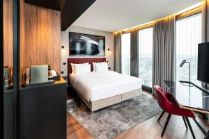 Un pat sau paturi într-o cameră la Radisson Blu Hotel at Porsche Design Tower Stuttgart