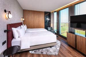 Un pat sau paturi într-o cameră la Radisson Blu Hotel at Porsche Design Tower Stuttgart
