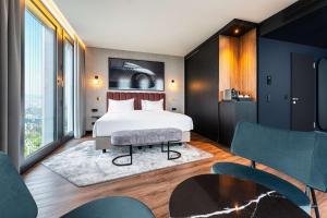 Un pat sau paturi într-o cameră la Radisson Blu Hotel at Porsche Design Tower Stuttgart