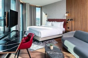 Un pat sau paturi într-o cameră la Radisson Blu Hotel at Porsche Design Tower Stuttgart