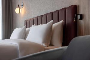 Un pat sau paturi într-o cameră la Radisson Blu Hotel at Porsche Design Tower Stuttgart