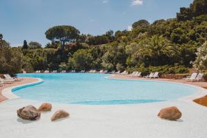 a swimming pool with rocks in the middle at Residence Il Mirto in Palau