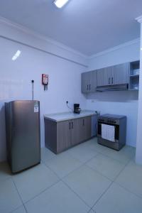 an empty kitchen with a refrigerator in a room at Rige's Homes 2Brm Furnished in Nairobi +10 photos