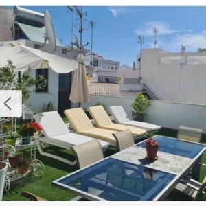 a patio with chairs and a table and an umbrella at La Tahona in Nerja