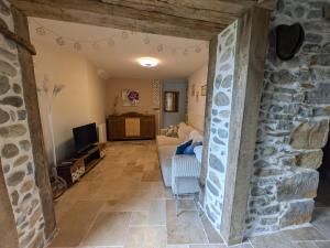 a living room with a stone wall and a couch at Les pierres qui parlent in Précilhon