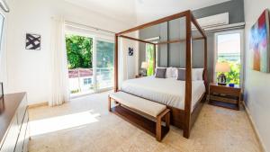 ein Schlafzimmer mit Himmelbett und großem Fenster in der Unterkunft Villa Collie Luxury Retreat7 King Master Brmaid in Sosúa + 115 Fotos