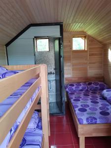 a room with two bunk beds and a shower at Kamp Vodeni Ćiro in Setihovo