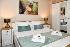 a bedroom with a large bed with two towels at Secret Yard Luxury Apartment in Anemómylos