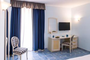 A television and/or entertainment centre at Baia dei Mulini Resort & Spa