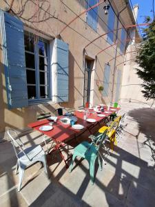 einem Picknicktisch mit Stühlen und Tellern darauf in der Unterkunft Croassecorbeau Maison de Famille au pied du Ventoux in Malaucène