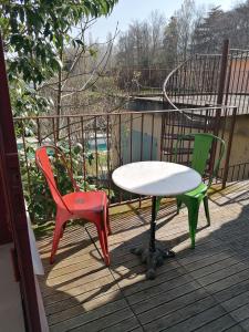 ein Tisch und zwei Stühle auf einem Deck in der Unterkunft Croassecorbeau Maison de Famille au pied du Ventoux in Malaucène