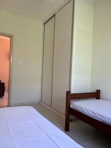 a bedroom with two beds and sliding glass doors at Casa Aconchegante em Ubatuba in Ubatuba