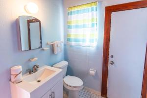 a bathroom with a sink and a toilet and a mirror at Blue in Santa Rosa Beach +30 photos