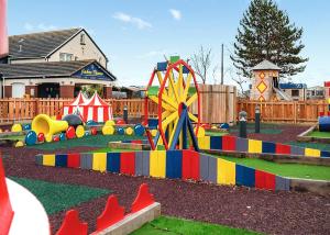 a childrens playground with a colorful play equipment at Whitehouse Holiday Park in Abergele
