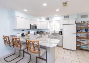 a kitchen with white cabinets and a white refrigerator at Sea Bluff #5 in Santa Rosa Beach