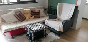 a teddy bear sitting on a couch with a chair at Studio Cozy Grant in Bucharest