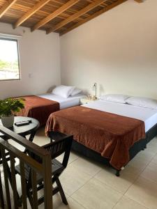 una camera con due letti e un tavolo con una sedia di Hermoso Aparta-Estudio En Envigado cerca de Medellin a Envigado