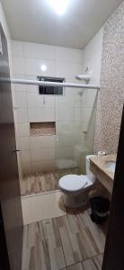 a bathroom with a toilet and a sink at Pousada Central Parque in Penha