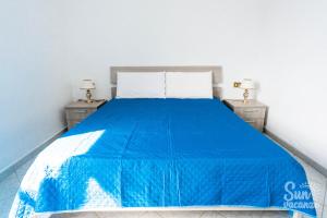 a bedroom with a blue bed with two night stands at Malamuri 5 sun vacanze in Budoni