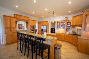 una cucina con armadi in legno e un'isola con sgabelli da bar di Bayside Bliss a Santa Rosa Beach