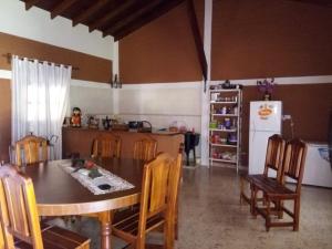 a kitchen with a table and chairs and a refrigerator at Peñemboha Katu in Estación Colonia Carolina