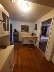 a kitchen with a desk and a bed in a room at Simply Suite - Sua Casa Longe de Casa in YYJ