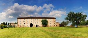 a large building in a field with a green field at Chianti 22 in Poggibonsi