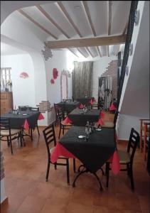 a dining room with tables and chairs with red napkins at Casa Rural La Palmera in Cañada del Trigo