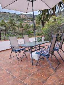 a table and chairs with an umbrella on a patio at Casa Fina in Vallehermoso +2 photos