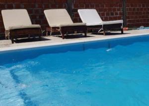 two chairs sitting next to a swimming pool at Hermosa Casa Alquiler Temporario in Corrientes