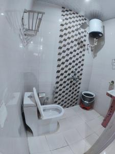 a white bathroom with a toilet and a shower at Golden Oak Villa Mussoorie in Rājpur
