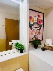 un baño con una pintura de una mujer con flores en Family Arena Prague, en Praga