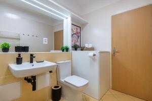 Un baño con un inodoro blanco y un lavabo. en Family Arena Prague, en Praga