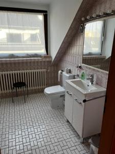 ein Badezimmer mit Toilette und Waschbecken und einem Fenster in der Unterkunft Schöne DG - Wohnung in Bonn in Bonn