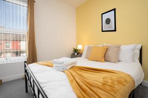 a bedroom with a bed with white sheets and a window at Entire 2 Bedroom Apartment-Free Parking & Super fast Internet - Sleeps 6 in Birkenhead