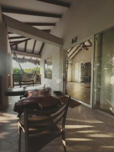 a room with a table and chairs and a hammock at SABAI Beach Hotel in Barú