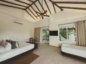a bedroom with two beds and a large window at SABAI Beach Hotel in Barú +57 photos