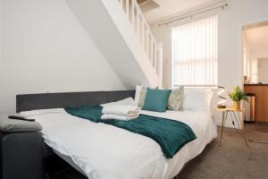 a bedroom with a large bed with green and white pillows at Entire 2 Bedroom Apartment-Free Parking & Super fast Internet - Sleeps 6 in Birkenhead