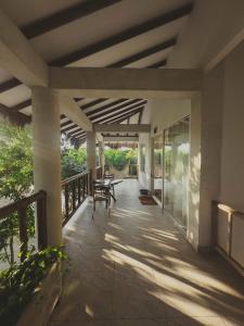 a porch of a house with tables and chairs at SABAI Beach Hotel in Barú