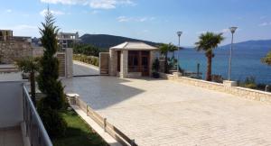 a building on the side of a road next to the water at White Residence Luxury Apartments in Sarandë