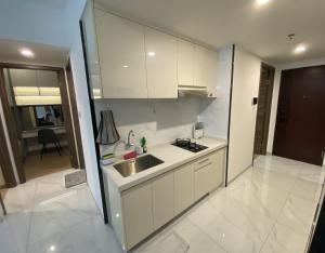 a kitchen with white cabinets and a sink in it at Sky House BSD in Samporo +3 photos