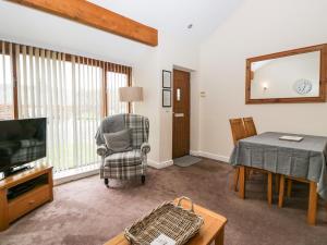 un salon avec une chaise et une télévision dans l'établissement 7 Sandpiper, à Carnforth