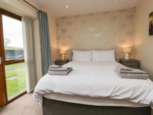 une chambre avec un grand lit et une fenêtre dans l'établissement 7 Sandpiper, à Carnforth