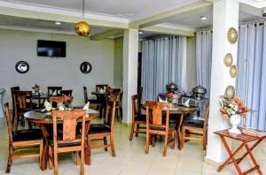 a dining room with wooden tables and chairs at Hotel Casabella in Entebbe